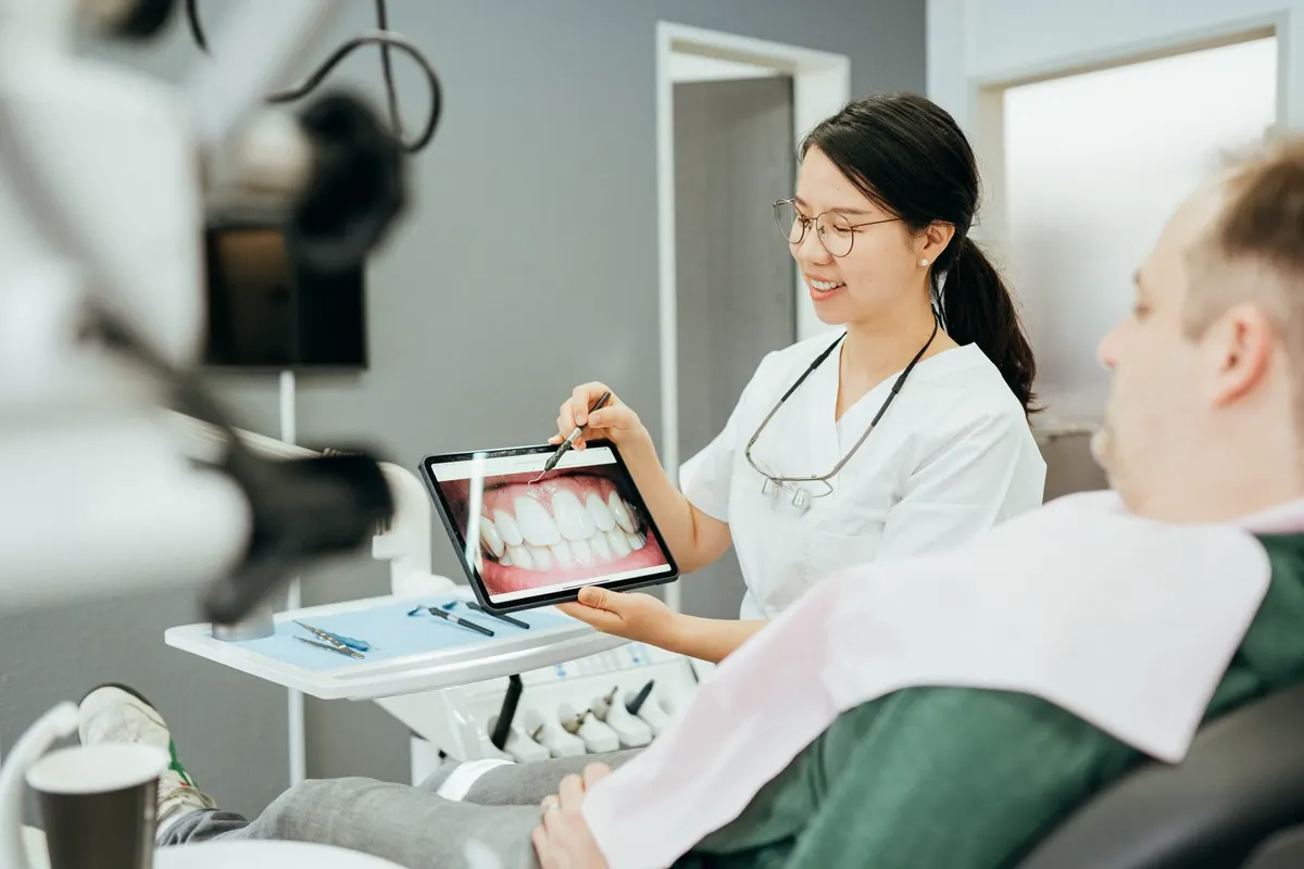 Dr. Jiang erklärt einem Patienten die Behandlung am Tablet